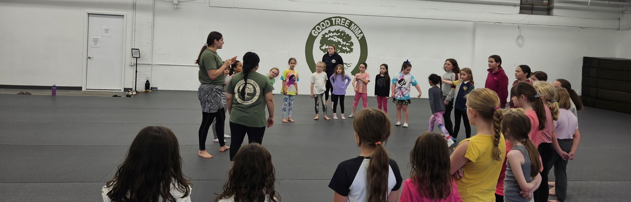 a group of youngsters stands in a semi-circle around their instructors at Wilkes Barre Good Tree MMA